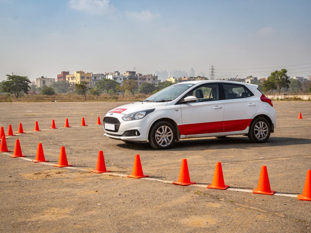 A driving school training car on a practice ground with traffic cones