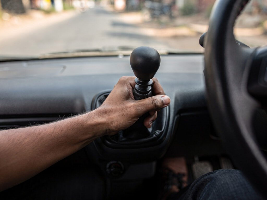 Hand on the gear lever of a manual transmission car