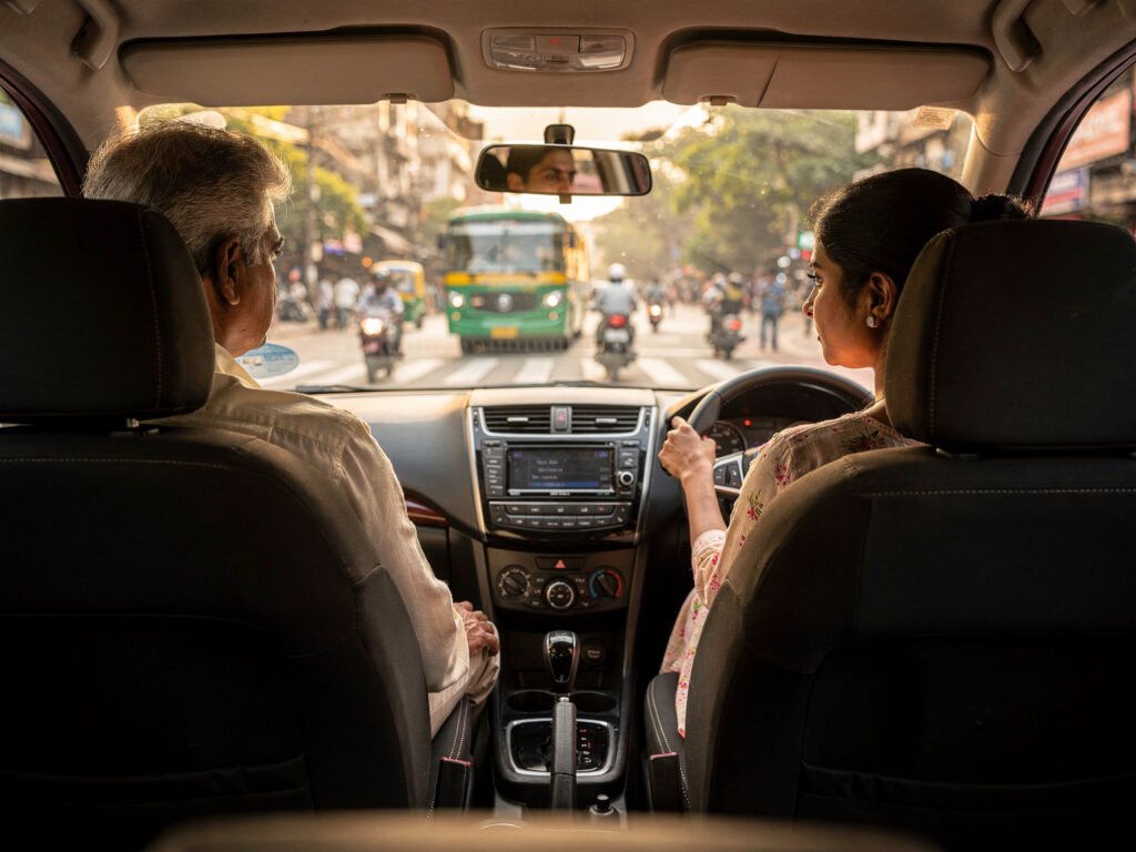 A learner driving in city traffic while an instructor supervises a defensive driving lesson